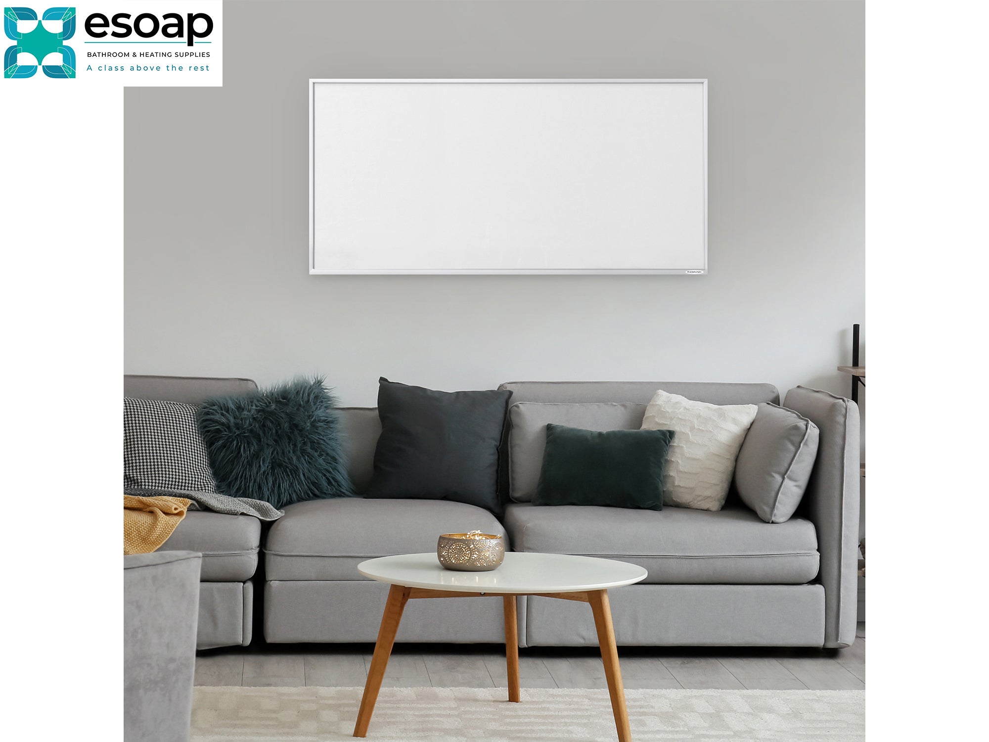 Gray sectional sofa with decorative pillows in a living room setting, featuring the esoap logo and wall hanging 700W Classic Infrared Heating Panel Black