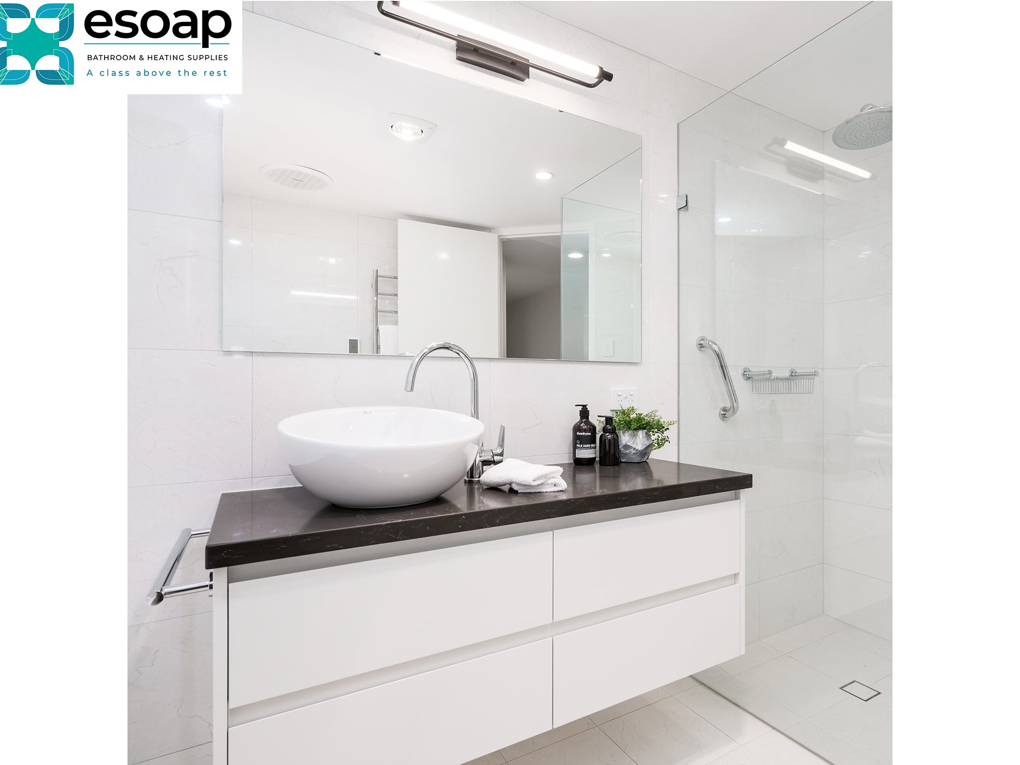 Modern bathroom with a sink and toiletries and 580W Mirrored Wi-Fi Infrared Heating Panel featuring the Esoap brand.