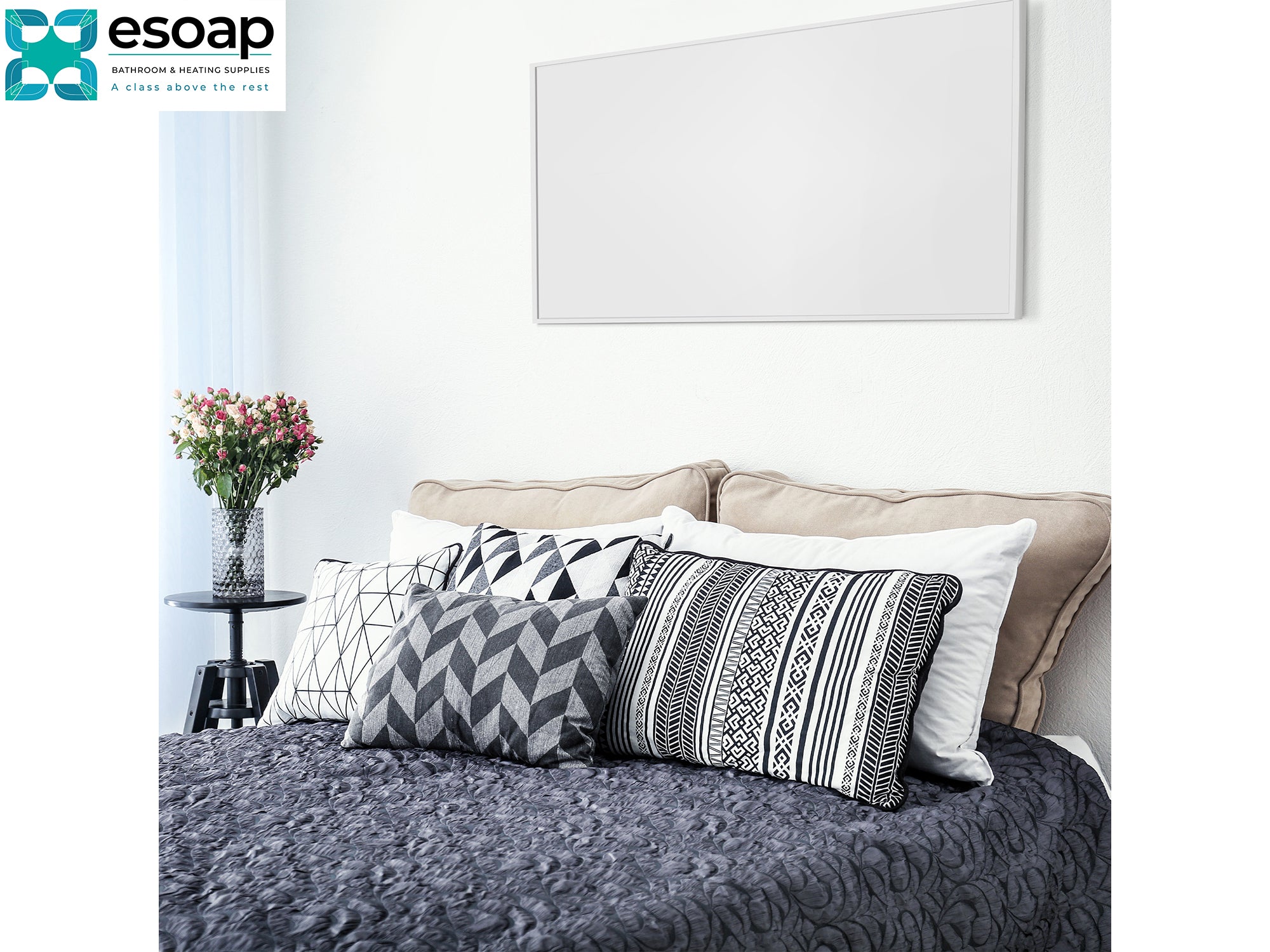 Decorative pillows on a bed with a 'esoap' logo in the corner back wall with Black 580W Classic Infrared Heating Panel